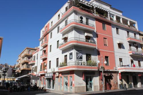 Un alto edificio bianco e rosso su una strada di città di B&B Le Terrazze a Crotone