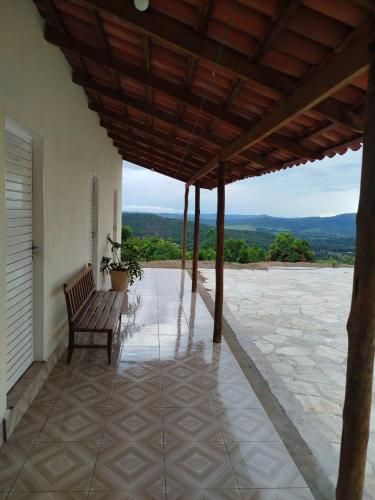 a porch with a bench sitting on top of a building at Recanto 3 Marias in Pirenópolis