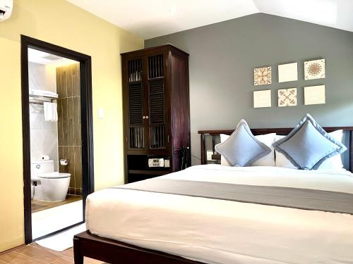a bedroom with a large bed with blue pillows at Hoianan Boutique Hotel in Hoi An