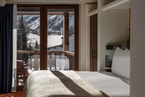 a bedroom with a bed and a balcony with a view at Experimental Chalet Val d'Isère in Val dʼIsère
