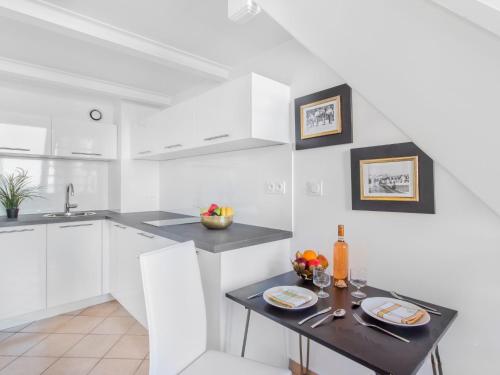une cuisine avec des placards blancs et une table avec des verres à vin dans l'établissement Studio Studio Republique by Interhome, à Toulon