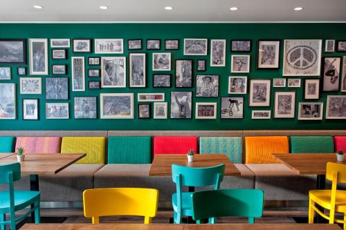 um restaurante com mesas coloridas e quadros na parede em Tallink Express Hotel em Talin