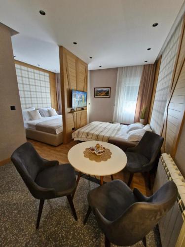a hotel room with a bed and a table and chairs at WILD BEAUTY Apartment-Modern mountain 2 in Kolašin