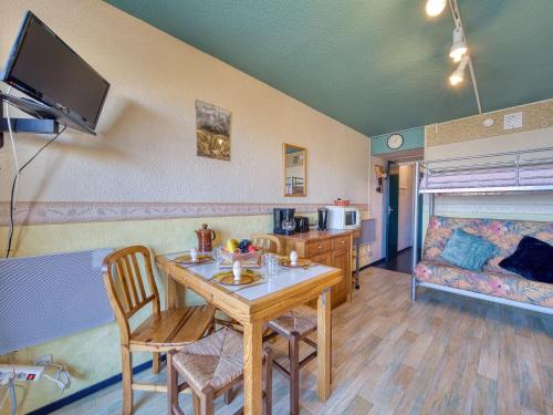 ein Wohnzimmer mit Tisch, Stühlen und Sofa in der Unterkunft Studio Soyouz Vanguard-103 by Interhome in Le Corbier