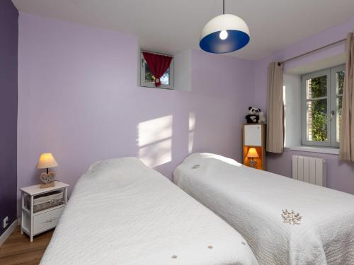 deux lits dans une chambre aux murs violets dans l'établissement Apartment Le Fournil by Interhome, à Mont-Dol