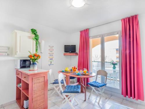 une cuisine avec une table et des chaises et une fenêtre dans l'établissement Apartment Les Canoubiers III by Interhome, à La Londe-les-Maures