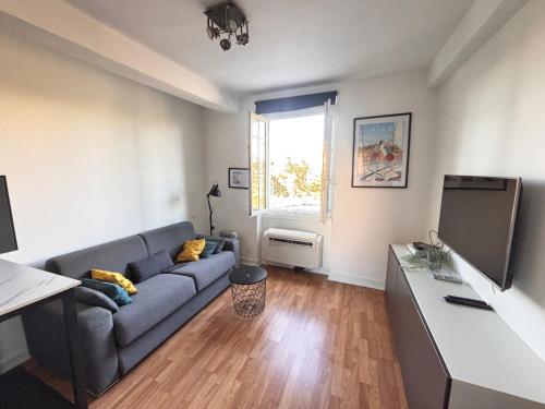 un salon avec un canapé et une télévision à écran plat dans l'établissement Studio au cœur de Nice lumineux, à Nice