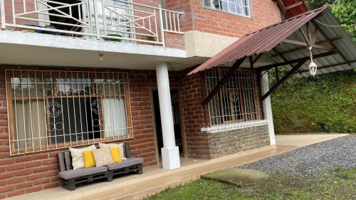 a brick building with a bench under a balcony at Casa Vip 1 in Puyo