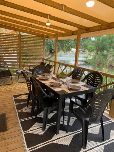 une table à manger et des chaises sur une terrasse avec vue dans l'établissement Siblu Village Les Viviers Bassin d'Arcachon mobile home neuf climatisé 3 chambres, à Lège-Cap-Ferret