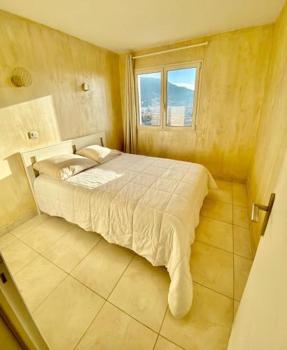 une chambre avec un grand lit avec une fenêtre dans l'établissement Appartement 4 pièces avec vue mer et stationnement privé à Nice, à Nice