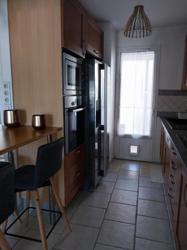 Il comprend une cuisine équipée d'un réfrigérateur, d'une table et de chaises. dans l'établissement Appartement 4 pièces avec vue mer et stationnement privé à Nice, à Nice