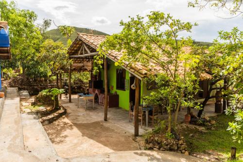 a green house with a table and chairs in front of it at Hospedagem Morro dos Muricis in Piumhi