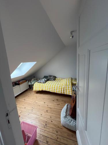 Schlafzimmer im Dachgeschoss mit einem Bett und einem Fenster in der Unterkunft Maison entière paisible à 5 minutes de Lille in Saint-André