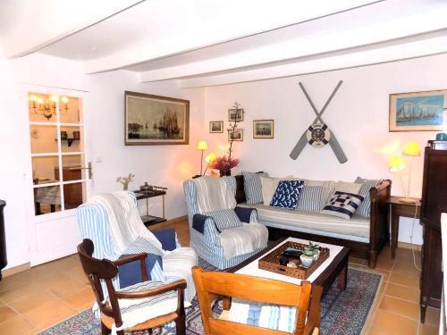 un salon avec un canapé et des chaises dans l'établissement Les Mathes La Palmyre - MAISON CHARENTAISE DE CHARME - CALME -CAMPAGNE, aux Mathes