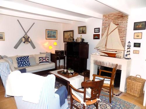 un salon rempli de meubles et d'une cheminée dans l'établissement Les Mathes La Palmyre - MAISON CHARENTAISE DE CHARME - CALME -CAMPAGNE, aux Mathes