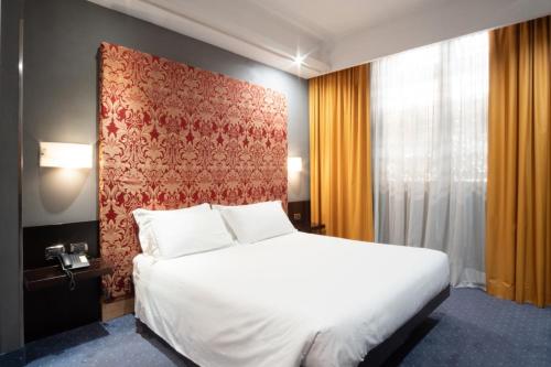 a bedroom with a white bed and a red wall at Hotel IMPERATORI in Rome