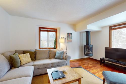 a living room with a couch and a tv at The Queens Slopeside Hideaway in Jay