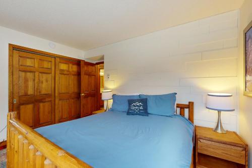 a bedroom with a bed with blue pillows at The Queens Slopeside Hideaway in Jay