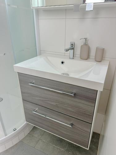 a bathroom with a white sink and a mirror at Serenity Apartment - Comfort in Leoben