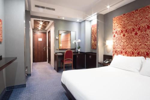pokój hotelowy z łóżkiem i biurkiem w obiekcie Hotel IMPERATORI w Rzymie