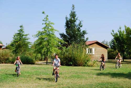 a group of children riding bikes in the grass at Lagrange Grand Bleu Vacances – Résidence Port Lalande in Castelmoron-sur-Lot