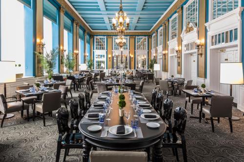 a dining room with tables and chairs and a chandelier at Lord Baltimore Hotel in Baltimore