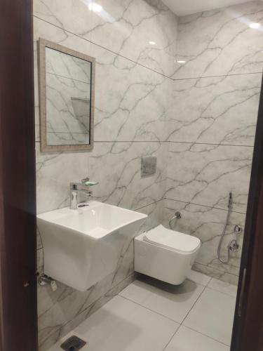 a white bathroom with a sink and a toilet at Hotel G-3 in Jalandhar