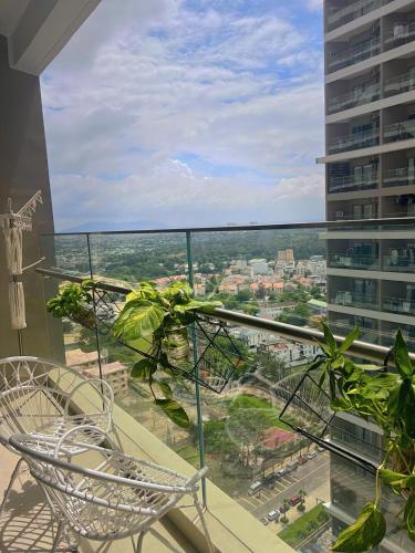 a balcony with two chairs and a view of a city at The Song Apartment 5 Stars Vung Tau - Căn Hộ Du Lịch 5 Sao Cạnh Biển - Dumin's Homestay in Vung Tau