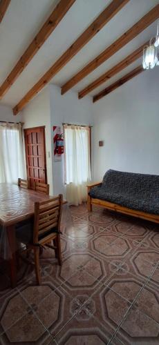 a room with a table and a bed and a table and chairs at Calendulas del Cabo in Trevelín