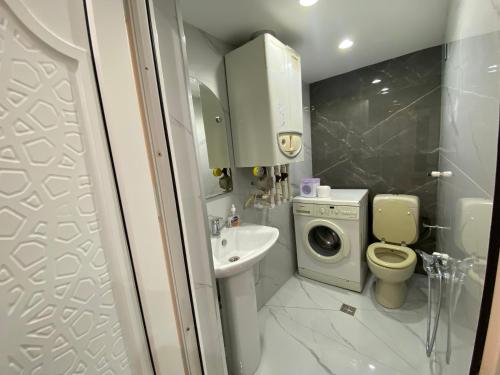 a bathroom with a sink and a toilet and a washing machine at House in Quba in Quba