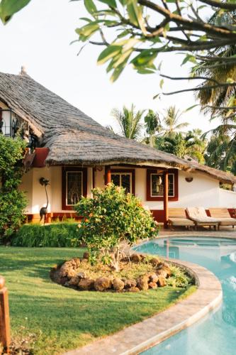 a house with a swimming pool in front of a house at Villa Keur Koba in Saly Portudal