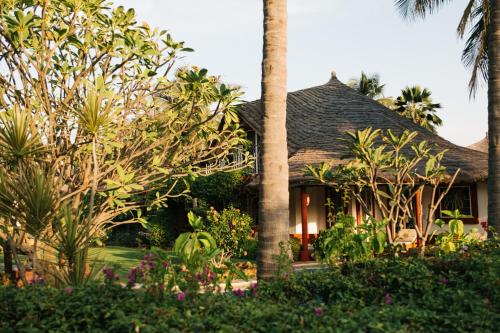 un complejo con una palmera y un edificio en Villa Keur Koba, en Saly Portudal