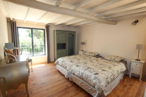 une chambre avec un lit et une grande fenêtre dans l'établissement La ferme du Loup, à Cucuron