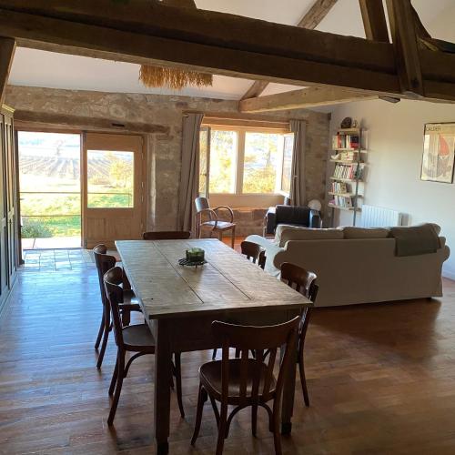 un salon avec une table et des chaises en bois dans l'établissement Les vins de Rouyré - Maison, 4 pers, grand jardin, bain nordique, à Sainte-Cécile-du-Cayrou