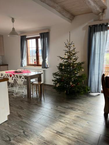 un árbol de Navidad en una sala de estar con mesa en Carlina House Szczawnica, en Szczawnica