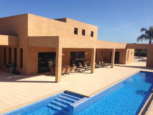 a building with a swimming pool in front of a house at Villa Casa Santana - Heated Pool in Lagos