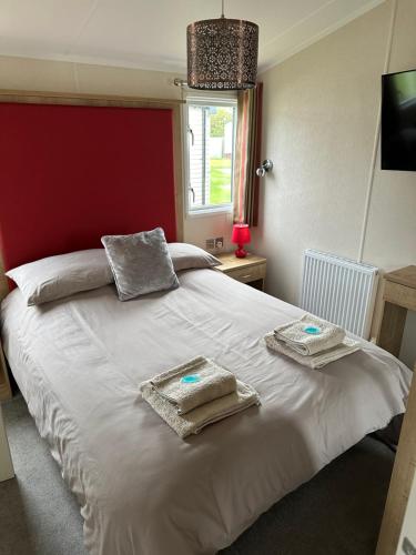 a bedroom with a white bed with towels on it at 13 Chorley close in Walton-on-the-Naze
