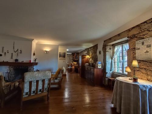a living room with a table and a stone wall at casa na aldeia - entre Fundão e Covilhã in Pêro Viseu