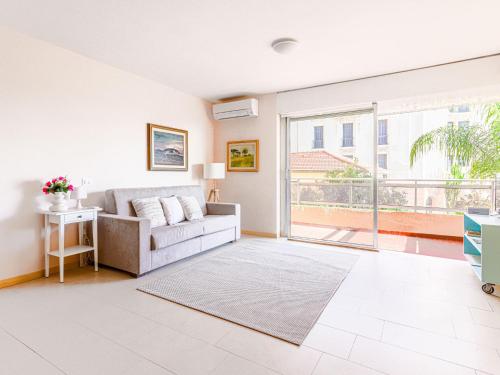 un salon avec un canapé et une grande fenêtre dans l'établissement Apartment Le Diplomate by Interhome, à Menton