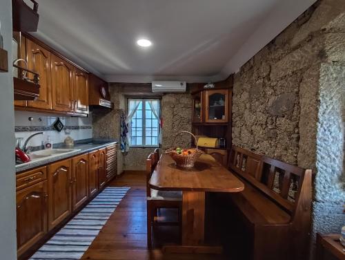 een keuken met houten kasten en een houten tafel bij casa na aldeia - entre Fundão e Covilhã in Pêro Viseu