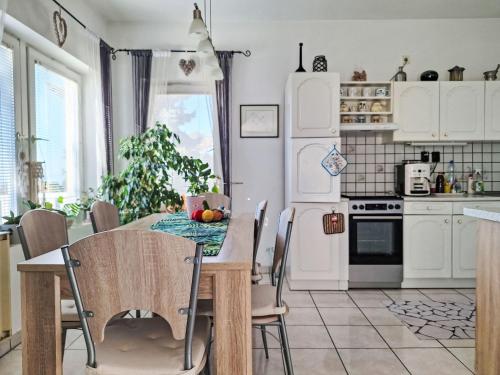 a kitchen with a table and chairs in a kitchen at Apartment Bonika by Interhome in Fonyód