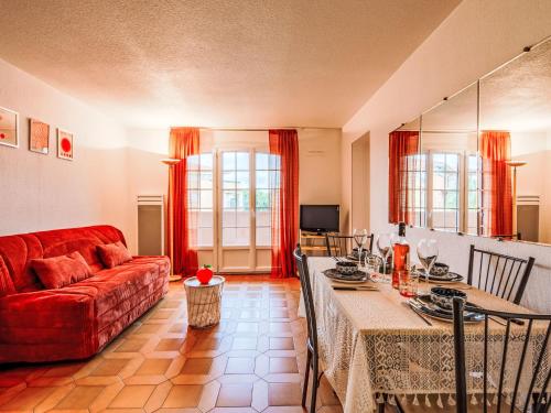 un salon avec un canapé rouge et une table dans l'établissement Apartment Le Ciel Bleu by Interhome, à Saint-Aygulf
