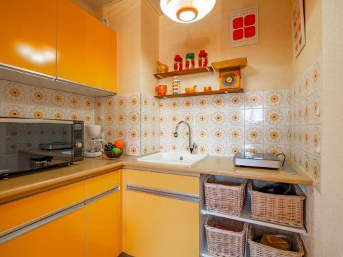 - une cuisine avec des placards jaunes et un évier dans l'établissement Apartment Le Ciel Bleu by Interhome, à Saint-Aygulf