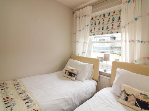 ダートマスにあるSunnyhavenの窓のある小さな部屋にベッドが2つある