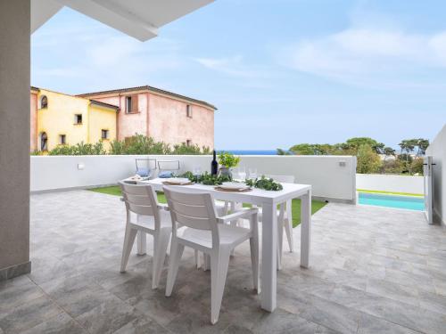 a white table and chairs on a patio at Apartment La terrazza sulla piscina by Interhome in Valledoria