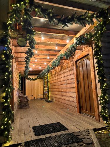 a porch with a wooden door and christmas garland at Bieszczadzki Zagajnik in Lesko