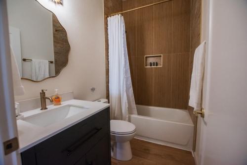 a bathroom with a sink and a toilet and a mirror at Terracotta Suite at ArnoTriplex! Hot Tub and Pet Friendly! in Albuquerque