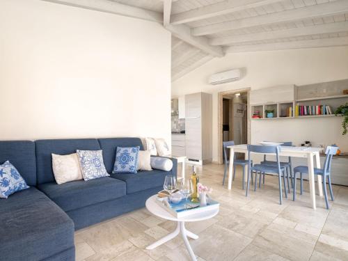 a living room with a blue couch and a table at Holiday Home La Conchiglia D'oro by Interhome in Budoni