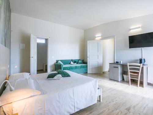 a bedroom with a white bed and a blue couch at Holiday Home Casa di Palaia by Interhome in Greve in Chianti