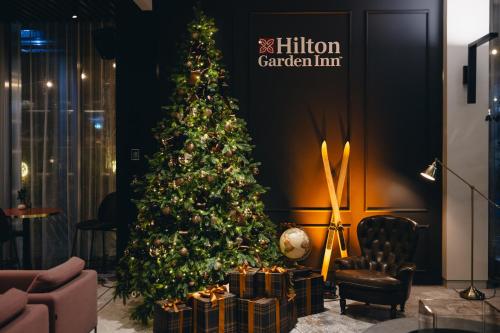 a christmas tree in a room with presents at Hilton Garden Inn Vilnius City Centre in Vilnius